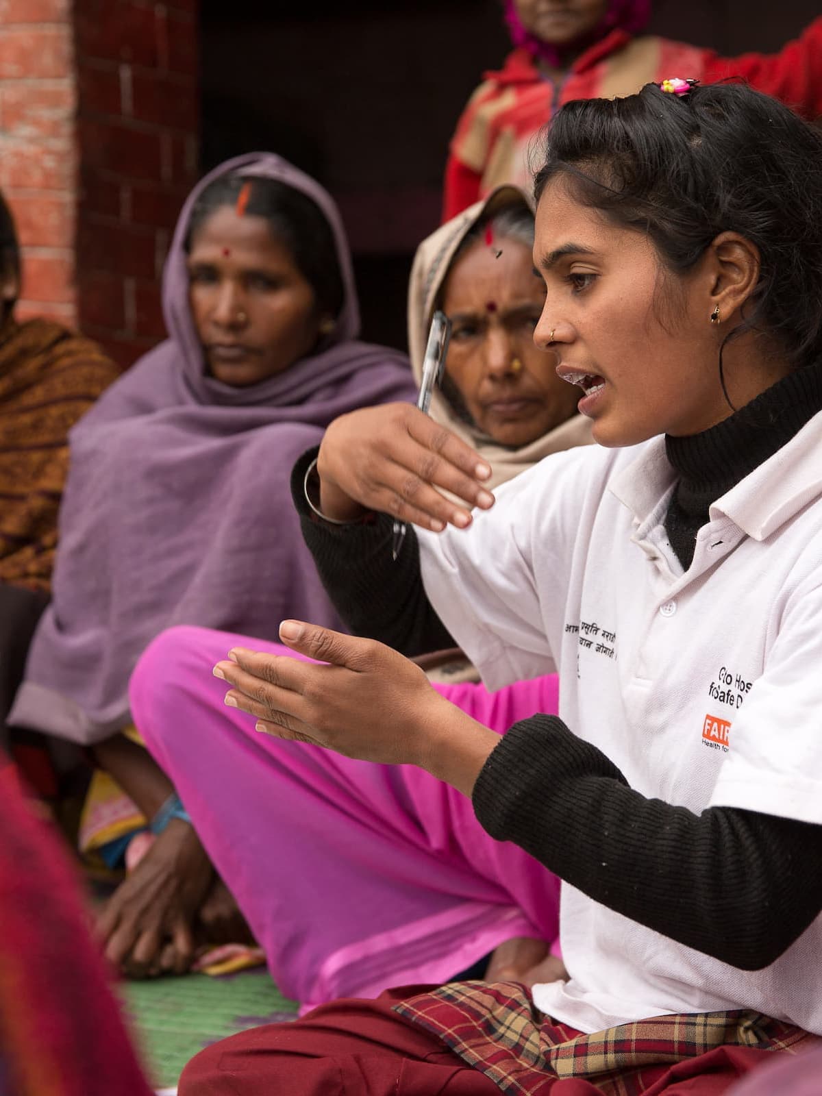 FAIRMED-Gesundheitshelferin leitet eine Müttergruppe in Nepal. Man sieht sie mit den anwesenden Frauen sprechen.